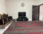 اتاق پذیرایی فرش شده به همراه مبلمان و تلوزوین رو میزی آپارتمان در اردبیل 478530497